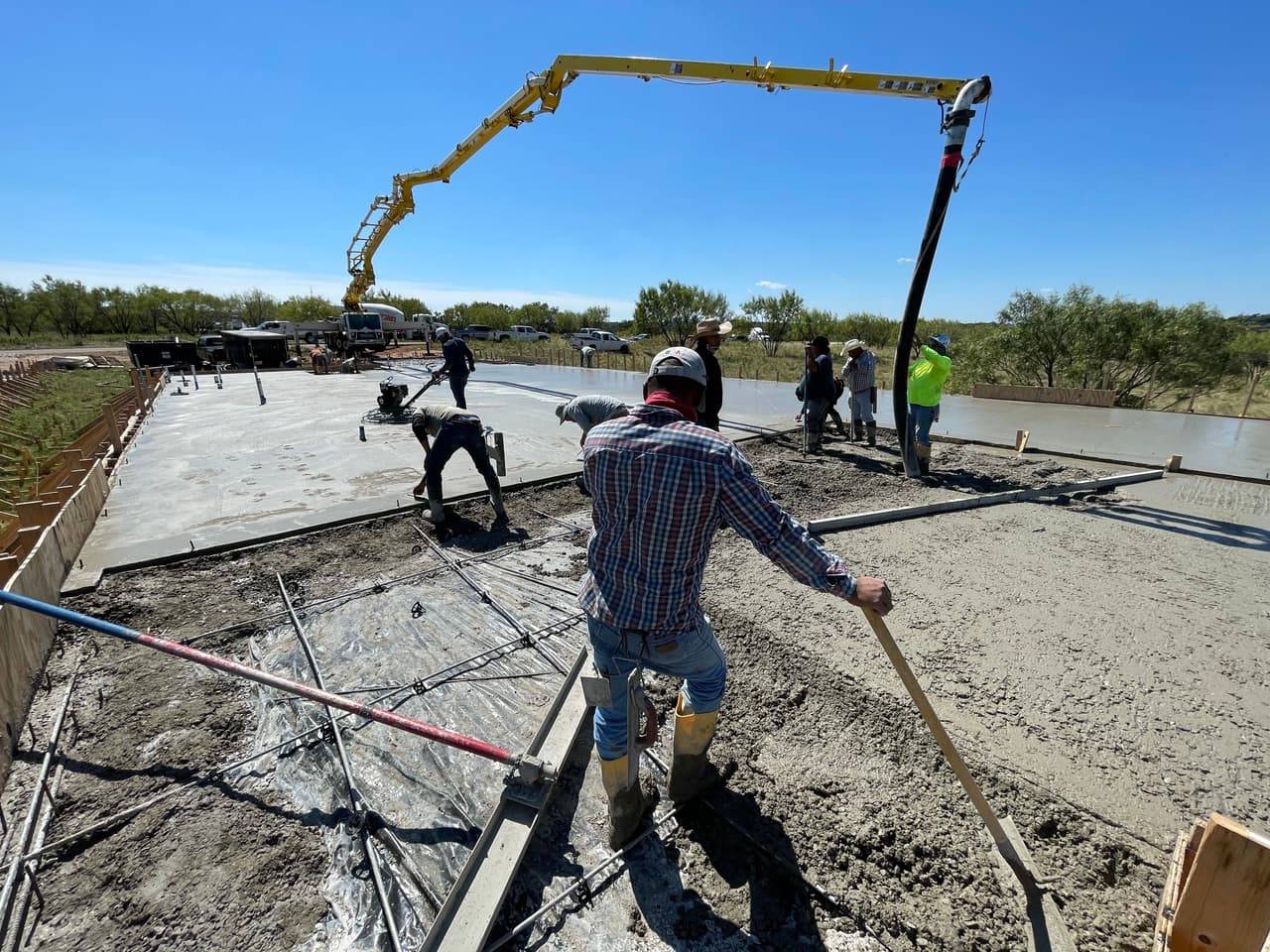 Graded and rebar-set site along a roadside driveway approach, ready for a concrete pour