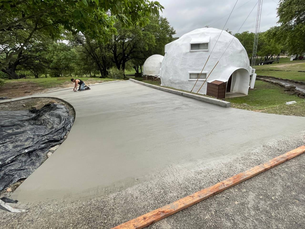 Concrete crew finishing a new driveway pour on a rural Highland Lakes property