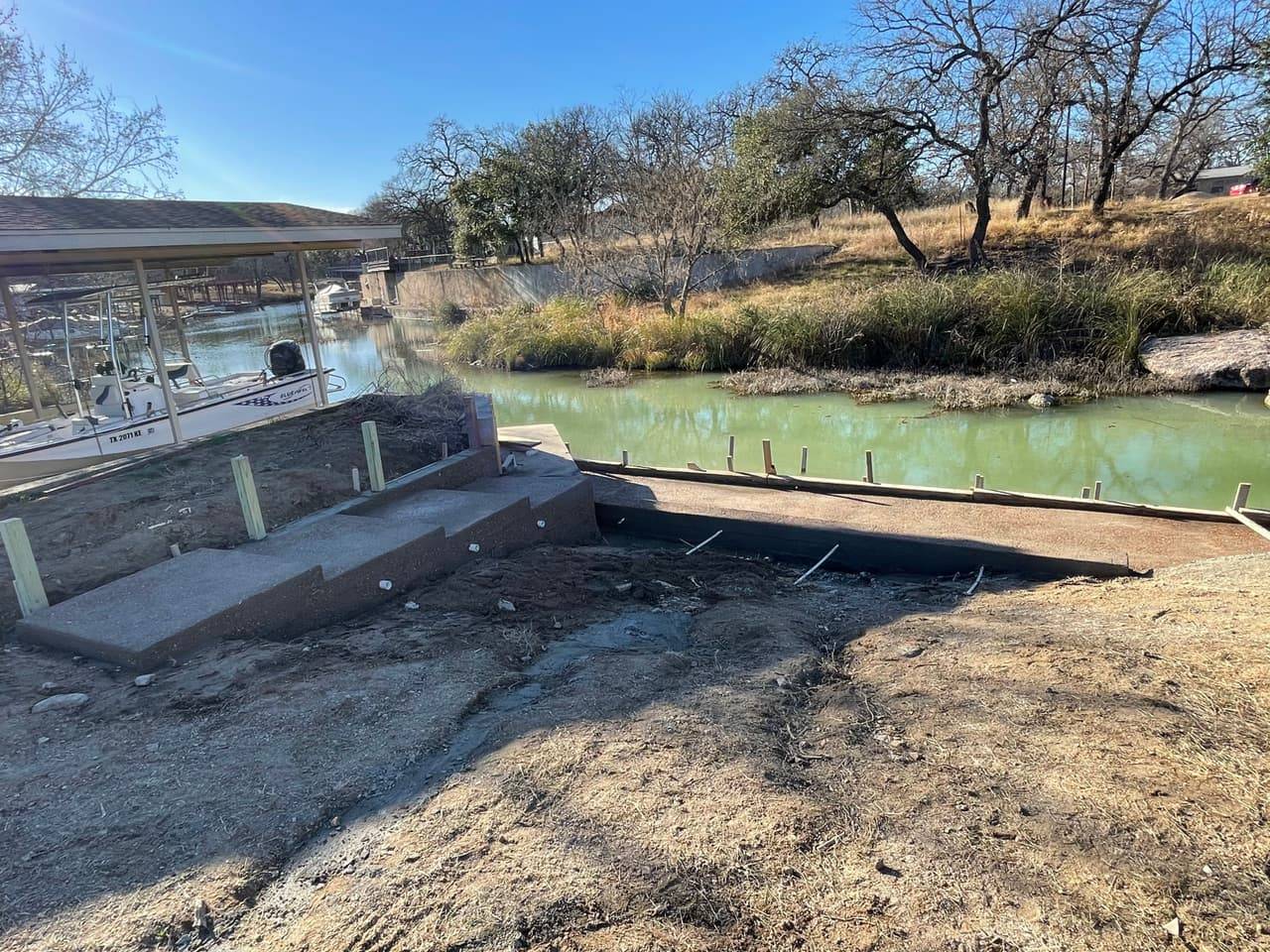 Concrete steps and retaining structure poured along the edge of a waterway boat dock