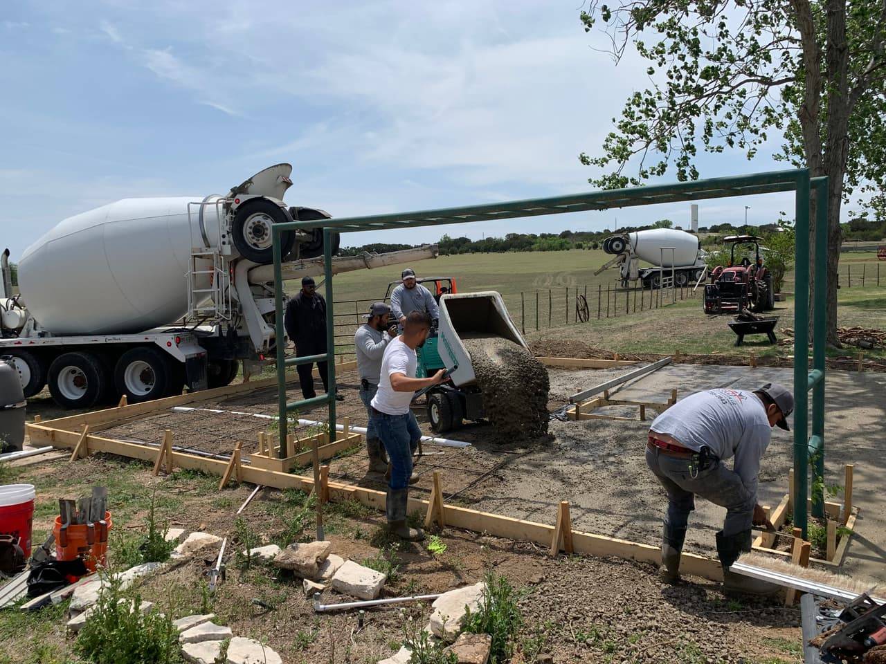 Concrete pump truck extended over a graded roadside site during a pour